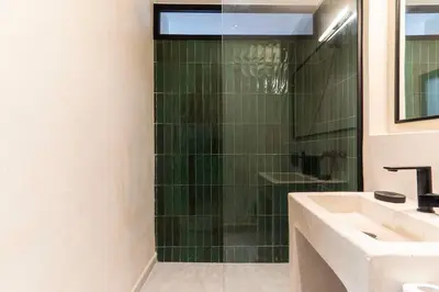 a bathroom with a sink and a glass shower at Majorelle Modern A Unique Green Cocoon in Marrakech