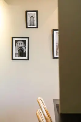 a wall with four pictures on a wall with a table at Majorelle Modern A Unique Green Cocoon in Marrakech