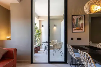 a dining room with a glass door leading into a living room at Majorelle Modern A Unique Green Cocoon in Marrakech