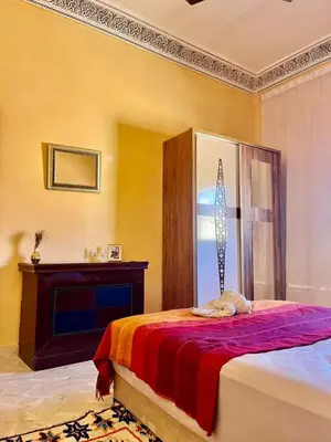 a bedroom with a bed and a fireplace in it at Spacieux Appart 2 chambres 6 Pers 12min Aéroport in Marrakech
