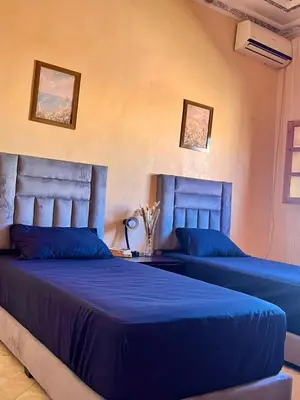 two beds with blue sheets in a bedroom at Spacieux Appart 2 chambres 6 Pers 12min Aéroport in Marrakech