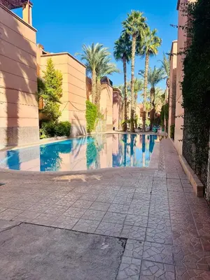 a swimming pool with palm trees on a street at Lina Stay Riad Alkaria Assiyahia in Marrakech
