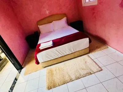 a bedroom with a bed in a pink wall at Lina Stay Riad Alkaria Assiyahia in Marrakech