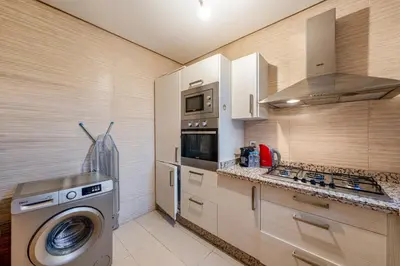 a kitchen with a washing machine and a washer at Cozy Apt with pool, Wifi, parking, Golf Views & Sunny Private Balcony in Marrakech