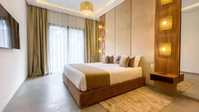 a bedroom with a large bed and a large window at Beautiful Villa Agathe with heated pool in Marrakech