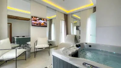 a bathroom with a tub with chairs and a table at Beautiful Villa Agathe with heated pool in Marrakech