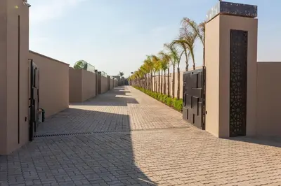 a sidewalk with palm trees on the side of a building at Beautiful Villa Agathe with heated pool in Marrakech