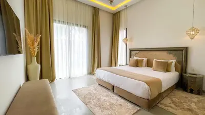 a bedroom with a bed and a large window at Beautiful Villa Agathe with heated pool in Marrakech
