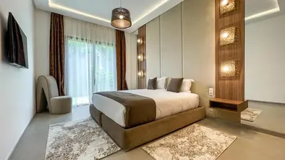 a bedroom with a bed and a large window at Syrine Villa with temperate pool, not overlooked in Marrakech