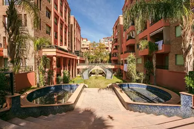 a courtyard with two pools in the middle of two buildings at The Good Mood - Hivernage Marrakech in Marrakech