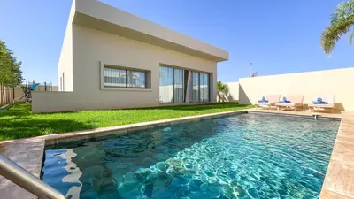 a swimming pool in front of a house at Beautiful Bianca villa with heated pool in Marrakech