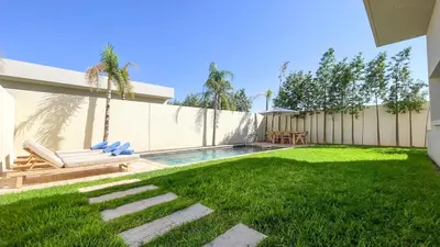 a backyard with a swimming pool and a fence at Beautiful Bianca villa with heated pool in Marrakech