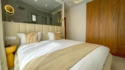 a bedroom with a large white bed with a large mirror at Beautiful Bianca villa with heated pool in Marrakech