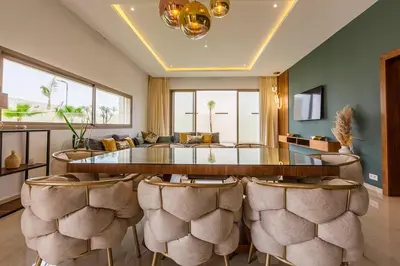 a living room with a large glass table and chairs at Jade Villa with pool in Marrakesh in Marrakech