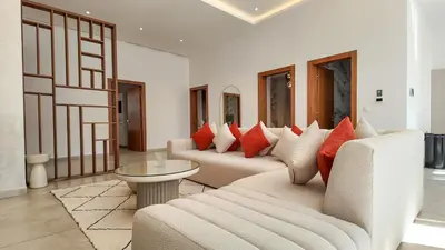 a living room with two couches with red pillows at Villa Amélia pool without opposite in Marrakech