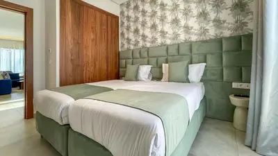a bedroom with a large bed with a green headboard at Villa Amélia pool without opposite in Marrakech