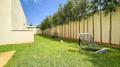 two soccer balls on the grass next to a fence at Villa Amélia pool without opposite in Marrakech