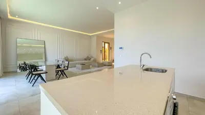 a kitchen and living room with a table and a couch at Villa Eden in Marrakech