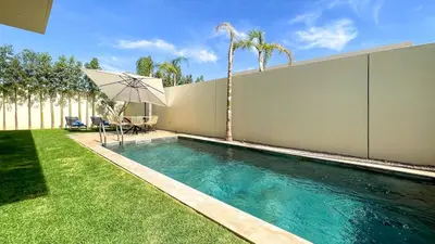 a swimming pool with an umbrella in a yard at Villa Eden in Marrakech