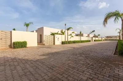 a cobblestone street in front of a white building at Beautiful Bahia villa with heated pool in Marrakesh in Marrakech