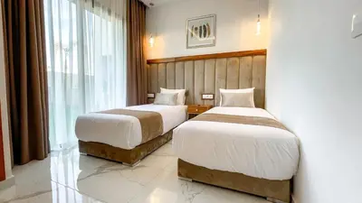 a hotel room with two beds and a window at Villa Alya with heated pool in Marrakesh in Marrakech