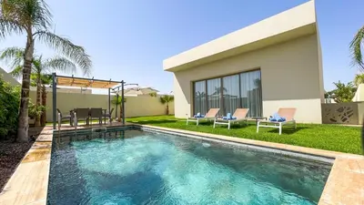 a swimming pool in front of a house at Villa Alya with heated pool in Marrakesh in Marrakech