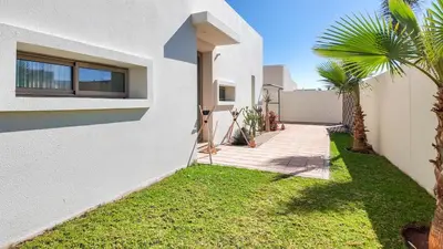a house with a green lawn next to a building at Villa DALIA in Marrakech