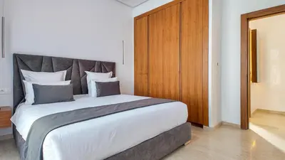 a bedroom with a large bed with a wooden headboard at Villa DALIA in Marrakech