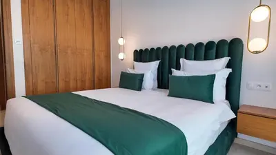 a bedroom with a large bed with green and white pillows at Villa DALIA in Marrakech