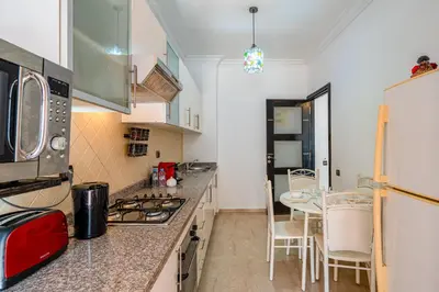 a kitchen with a stove top oven next to a table at Relaxing stay with pool & secure parking in Marrakech