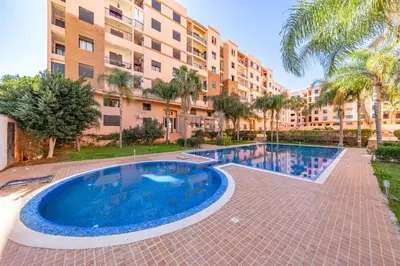 a large swimming pool in front of a building at Relaxing stay with pool & secure parking in Marrakech