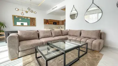 a living room with a couch and a glass table at Villa Balzac Marrakech with heated pool in Marrakech