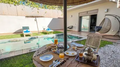 a table with food on it next to a swimming pool at Aman Bungalow - heated pool, not overlooked in Marrakech