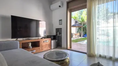 a living room with a large flat screen tv at Aman Bungalow - heated pool, not overlooked in Marrakech