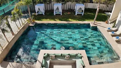 a large swimming pool with chairs in a backyard at Beautiful AWAL Villa, 6 suites & heated pool in Marrakech
