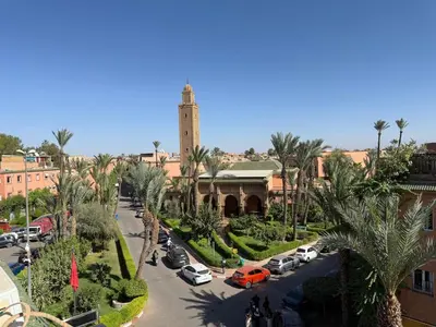 a city with a clock tower and a street with cars at Beautiful modern triplex in Qariya Sayhia in Marrakech
