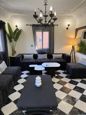 a living room with a couch and a table at Beautiful modern triplex in Qariya Sayhia in Marrakech