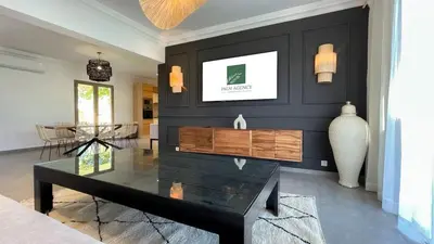 a living room with a black wall and a coffee table at Villa JAMAL with heated pool in Marrakech in Marrakech