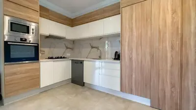 a kitchen with white cabinets and stainless steel appliances at Villa JAMAL with heated pool in Marrakech in Marrakech