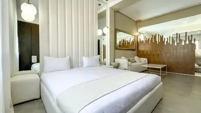 a bedroom with a large white bed and a living room at Beautiful Asma Villa with heated pool in Marrakech