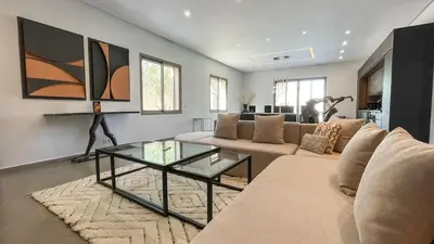 a living room with a couch and a glass table at Beautiful Asma Villa with heated pool in Marrakech