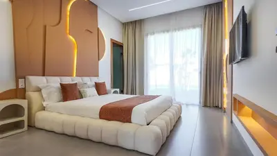 a bedroom with a large white bed with a couch at Villa Céleste avec piscine chauffée in Marrakech