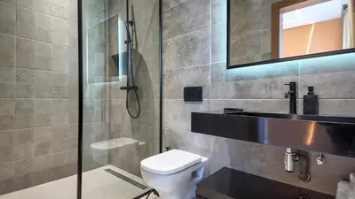 a bathroom with a shower and a toilet and a mirror at Villa Céleste avec piscine chauffée in Marrakech
