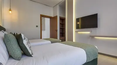 a bedroom with two beds and a flat screen tv at Villa Céleste avec piscine chauffée in Marrakech