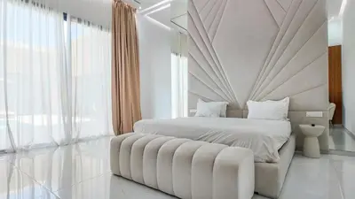 a white bedroom with a large bed and a large window at Villa Nour heated pool not overlooked in Marrakech