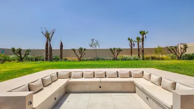 a bench in a park with palm trees at Villa Nour heated pool not overlooked in Marrakech