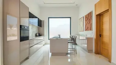 a kitchen with white cabinets and a table and chairs at Villa Nour heated pool not overlooked in Marrakech