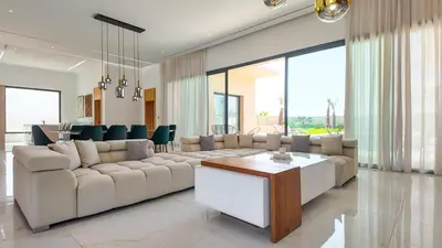 a living room with a large couch and a table at Villa Nour heated pool not overlooked in Marrakech
