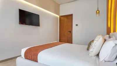 a white bedroom with a bed and a television at Villa Delina heated pool not overlooked in Marrakech