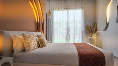 a bedroom with a bed with pillows and a window at Villa Delina heated pool not overlooked in Marrakech